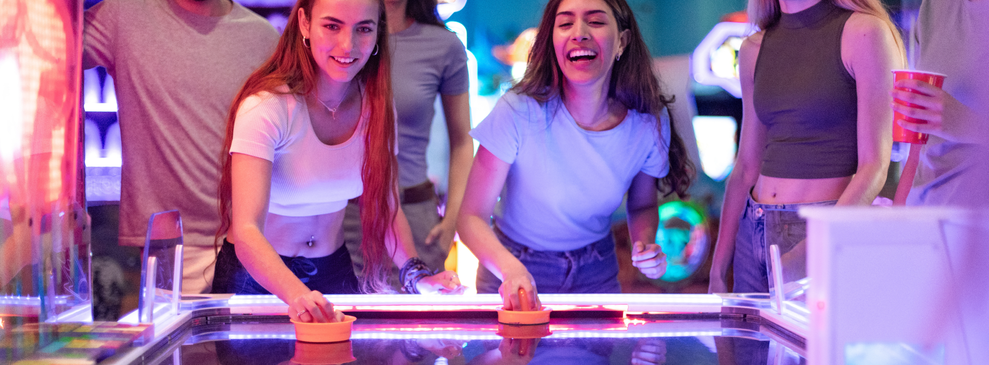 Personas en un centro de entretenimiento de Happyland disfrutando de un juego