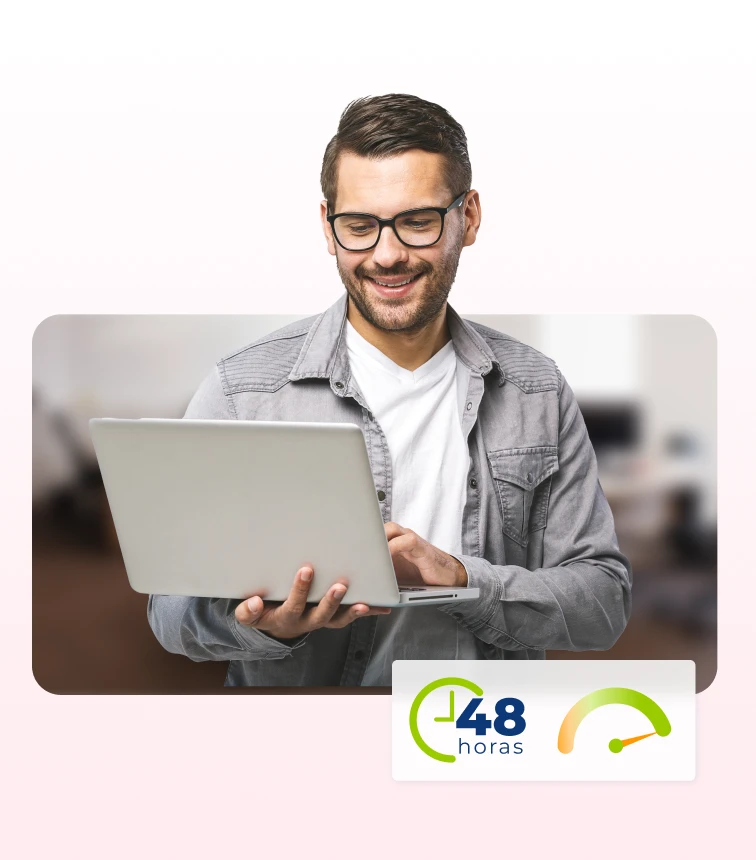 Homem de óculos, sorrindo e usando um notebook, representando a eficiência e agilidade do Software de Recrutamento Pandapé, que acelera processos de contratação em até 48 horas, como um ATS de grandes negócios.