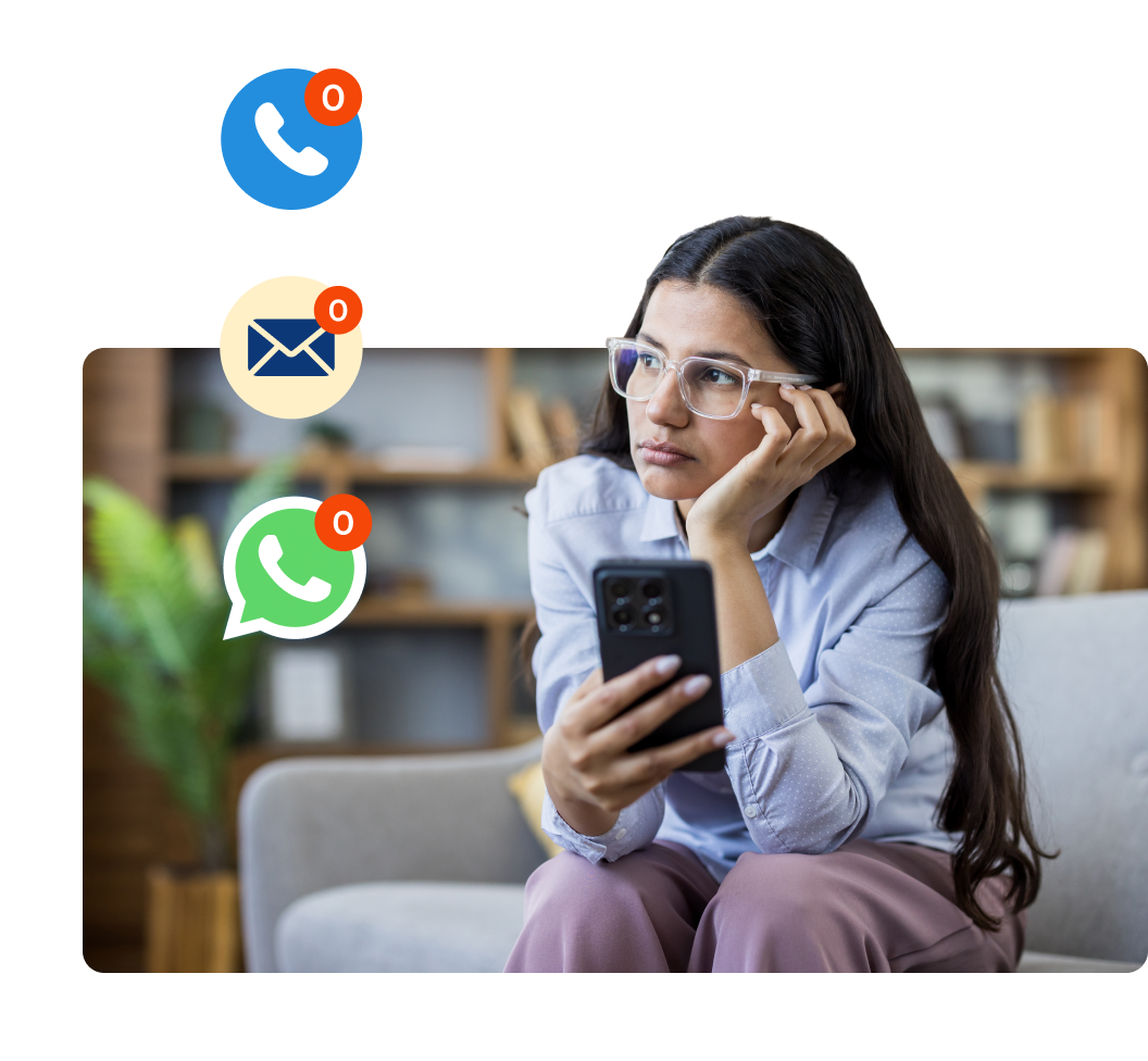 mujer morena con gafas y expresión aburrida sentada en un sofá mirando el móvil, alrededor los iconos de notificaciones de llamada, emails y whatsapp marcan cero